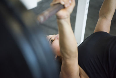 Athlete exercising with barbell in crossfit gym