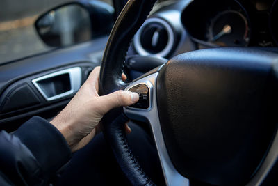 Midsection of person using smart phone in car