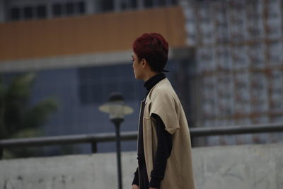 Side view of man standing against railing