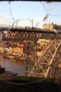 Bridge over river in city against sky