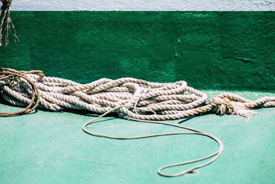 Close-up of rope tied on bollard against sea