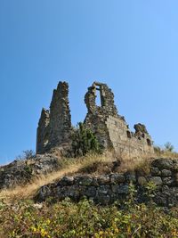 Low angle view of rock formation against clear blue sky