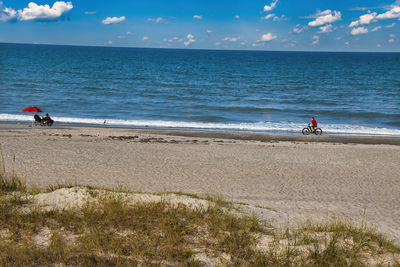 People on beach against sky