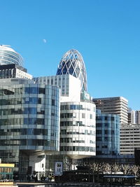 Low angle view of buildings against clear blue sky