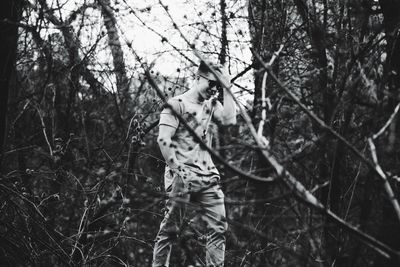 Man standing by tree in forest