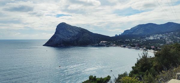 Scenic view of sea and mountains against sky