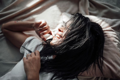 Midsection of woman lying on bed at home