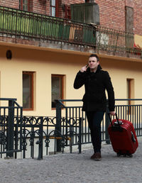 Mid adult man talking on mobile phone while walking on road