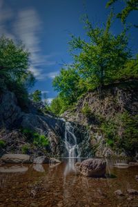 Scenic view of waterfall against sky