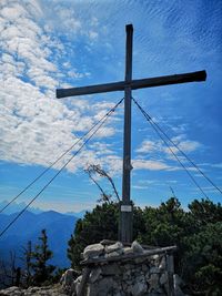 Low angle view of cross against sky