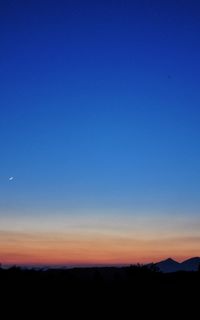 Scenic view of silhouette landscape against blue sky