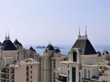 Buildings in city against clear sky