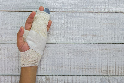 Low section of person holding umbrella on wood