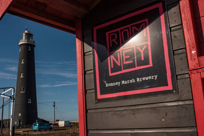 Low angle view of illuminated sign against sky