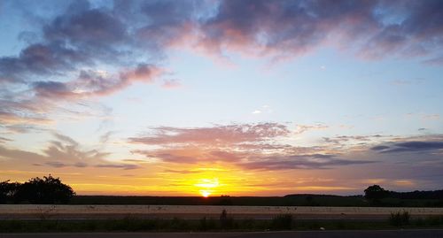 Scenic view of silhouette field against sky during sunset