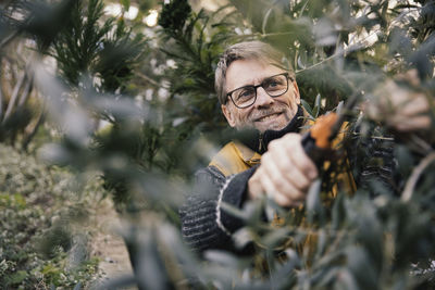 Portrait of smiling man holding plants