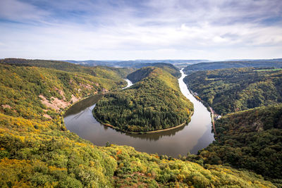 Scenic view of river amidst trees against sky