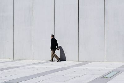 Full length of young woman standing on wall