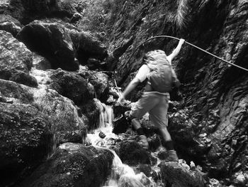 Full length of man on rock against waterfall