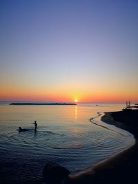 Scenic view of sea against clear sky during sunset