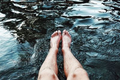 Low section of woman relaxing in swimming pool