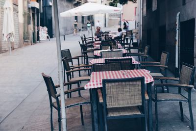 Row of tables and chairs at sidewalk cafe