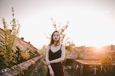 Portrait of smiling young woman standing against sky