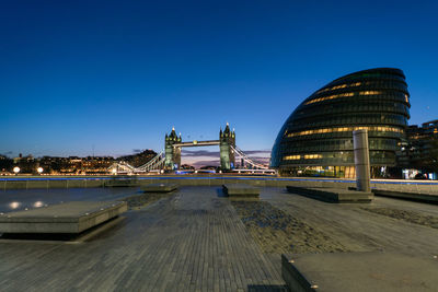 Illuminated modern buildings against sky at night