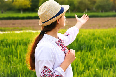 Side view of young woman standing on field