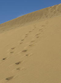 Sand dunes in desert against clear sky