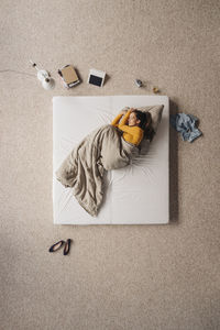 Woman lying in bed, top view