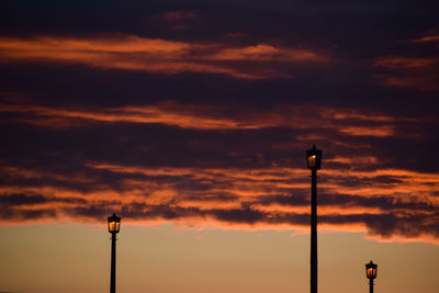 Low angle view of street light against orange sky