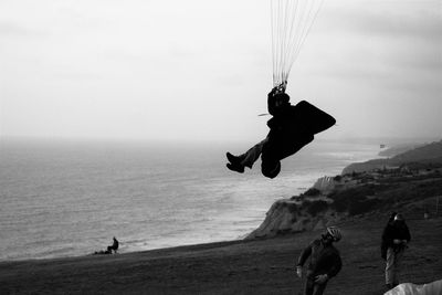 Tourist paragliding at coast