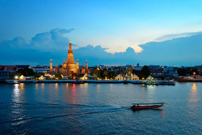 High angle view of motorboat sailing on river with city in background