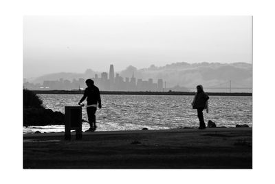 People looking at sea against sky