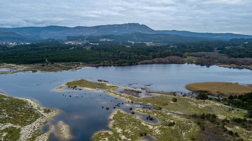 Scenic view of river by mountains against sky