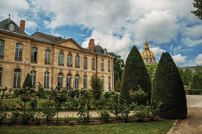 Panoramic view of garden with buildings in background