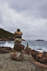 Stack of stones on beach against sky