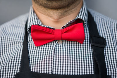 Close-up of man wearing red bow