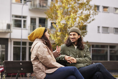 Man and woman talking on bench
