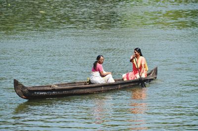 Women in rowing boat on lake