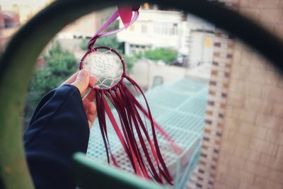 Midsection of person holding umbrella against window