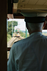 Rear view of engineer driving in train