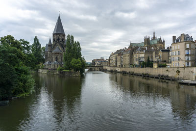 River by buildings against sky in city