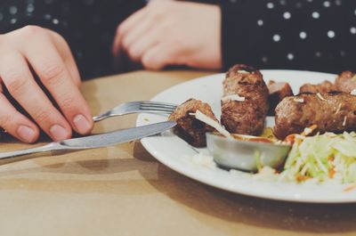 Close-up of hand holding food in plate