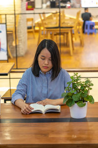 Woman reading book at cafe