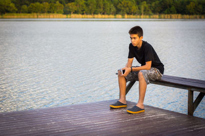 Portrait of boy sitting on lake