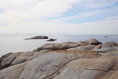 Rocks on sea shore against sky