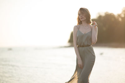 Woman walking at beach against sky