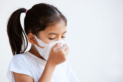 Girl wearing mask against white background